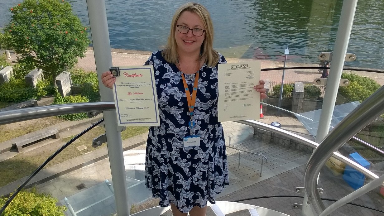 Lou Anderson holding up her award and certificate.